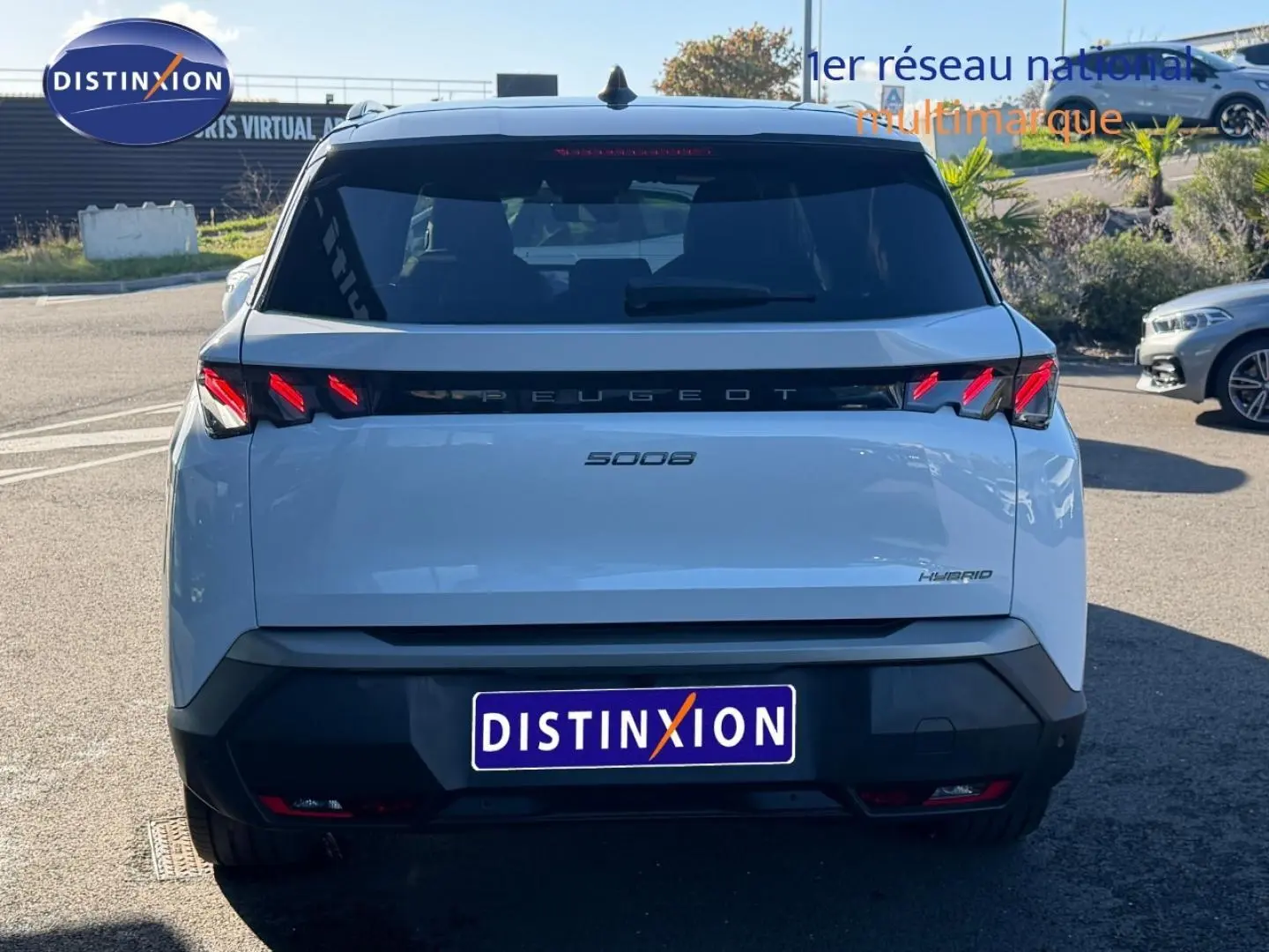 Vue arrière d'un Peugeot 5008 Hybrid blanc Okénite avec feux LED caractéristiques et logo central noir.