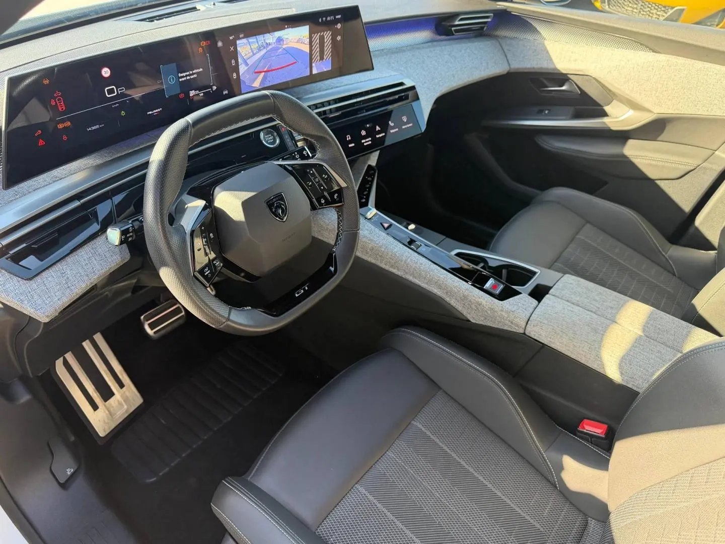 Vue intérieure côté conducteur du Peugeot 5008 Hybrid 145ch GT avec volant cuir multifonction et écran tactile panoramique.