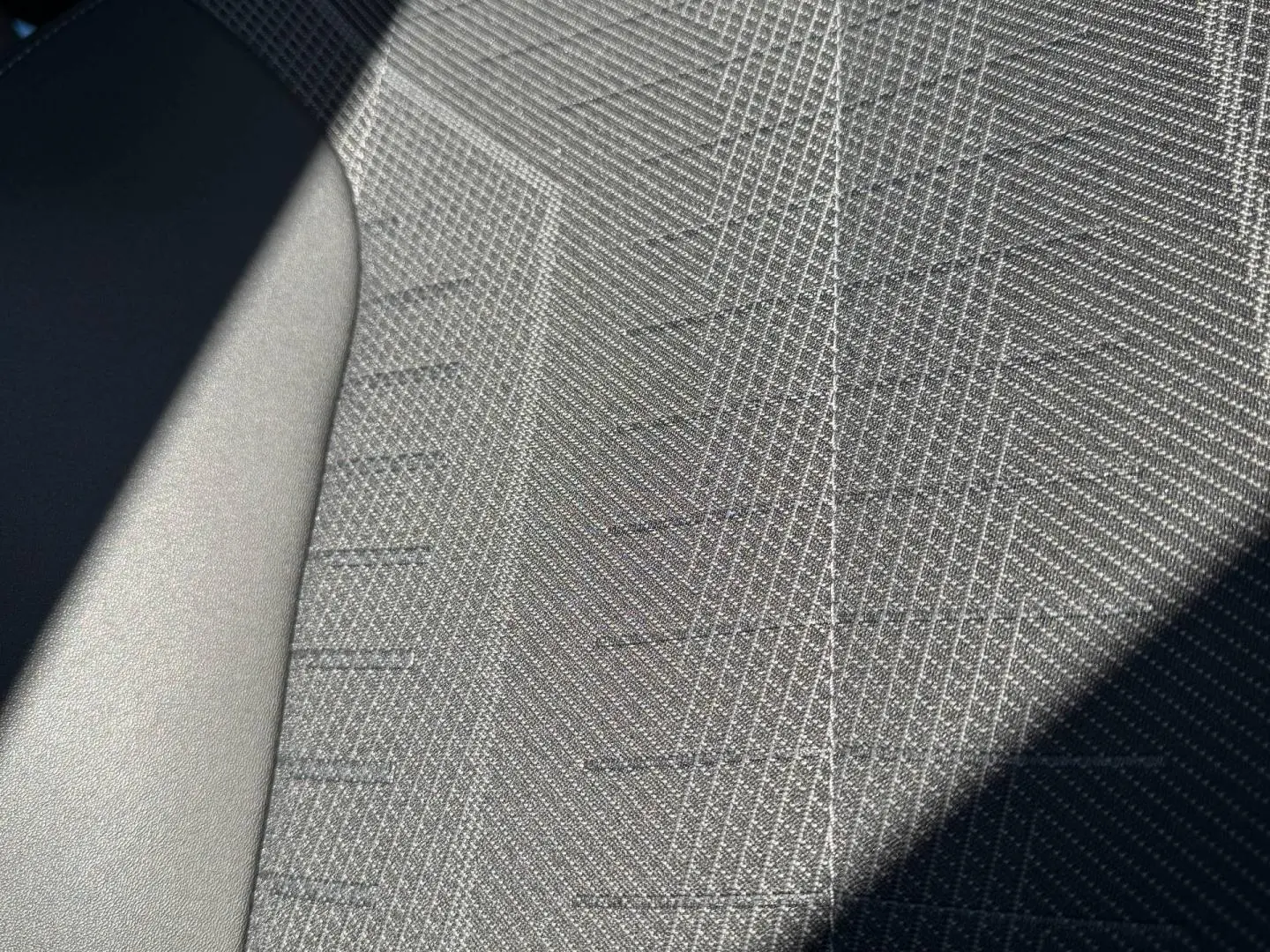 Gros plan sur le tissu gris texturé du siège avant du Peugeot 5008 Hybrid 145ch GT blanc Okénite.