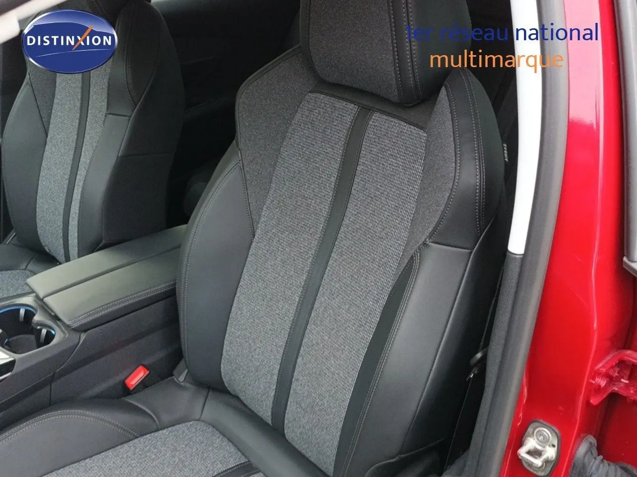 Gros plan sur le siège avant conducteur en tissu gris et cuir noir du Peugeot 3008 rouge foncé, porte ouverte.