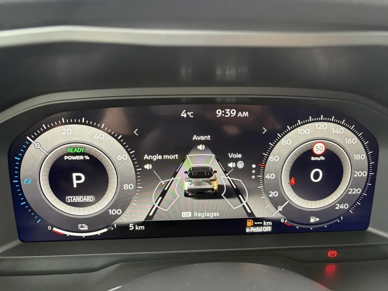 Affichage numérique du tableau de bord du Nissan Qashqai III hybride, montrant la vitesse, la température et l'assistance à la conduite.