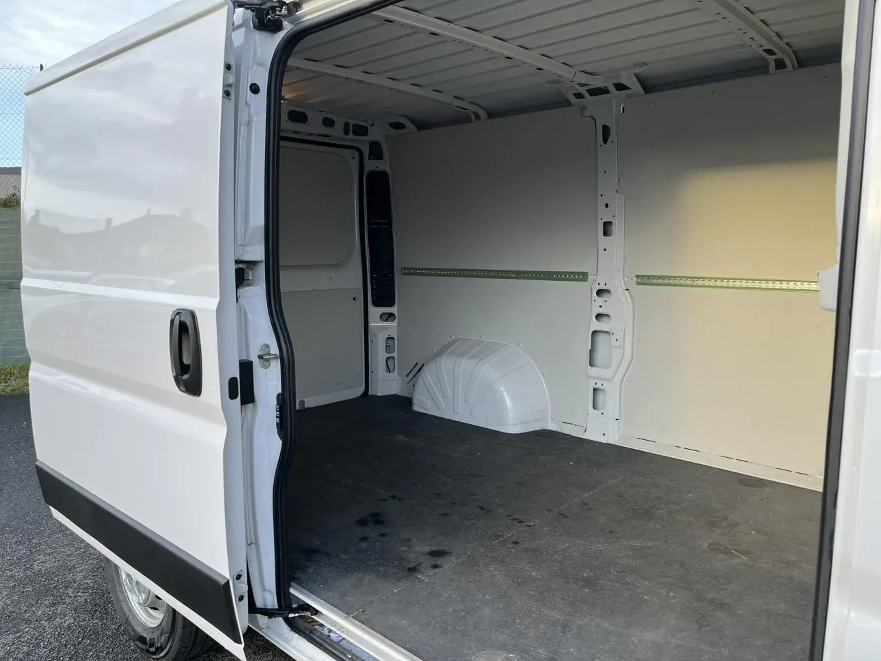 Vue latérale gauche d’un Opel Movano Fourgon blanc 2024 avec porte coulissante ouverte dévoilant l’espace de chargement vide.