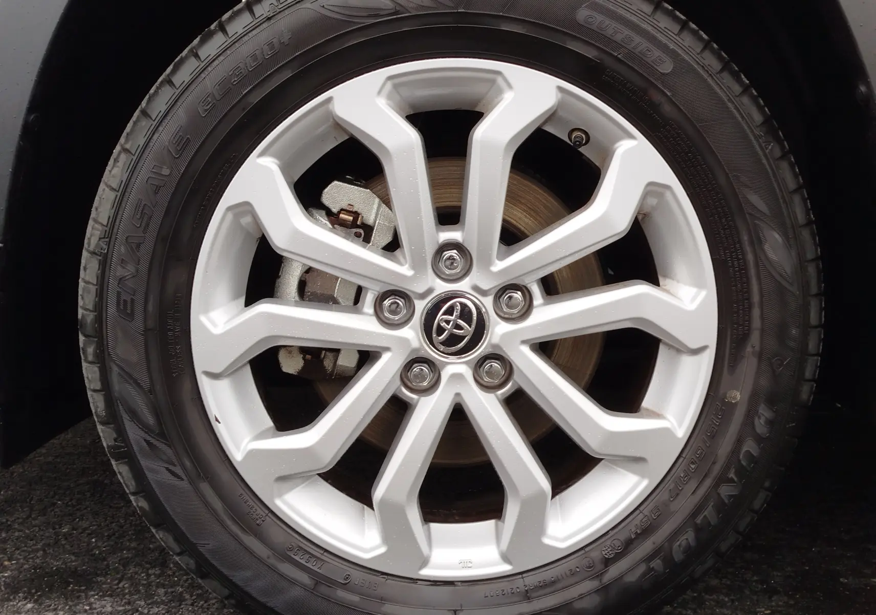 Gros plan sur la jante argentée en alliage du Toyota Corolla Cross 2025 noir intense, avec logo Toyota au centre.