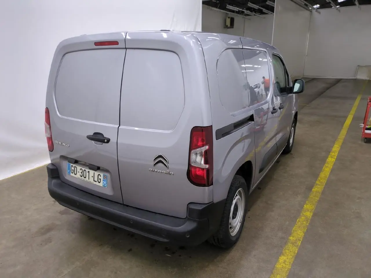 Vue 3/4 arrière droite d’un Citroën Berlingo gris clair utilitaire avec portes battantes arrière et pare-chocs noirs.