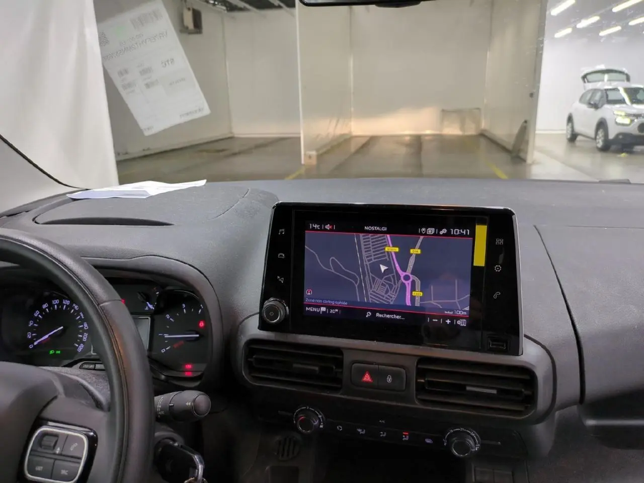 Vue intérieure du tableau de bord du Citroën Berlingo 2021, avec écran tactile de navigation et volant partiellement visible.