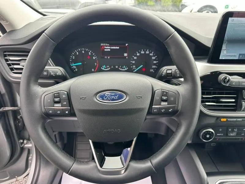 Vue rapprochée du volant cuir multifonction noir du Ford Kuga 2024 avec tableau de bord et écran tactile visibles.