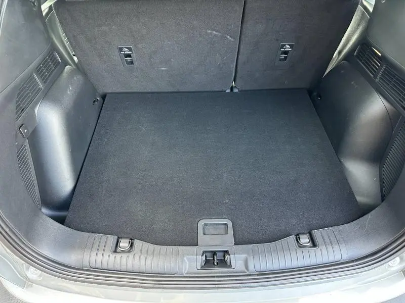 Coffre ouvert du Ford Kuga 2024 gris Solar, vue de dessus montrant un espace de chargement propre et plat.