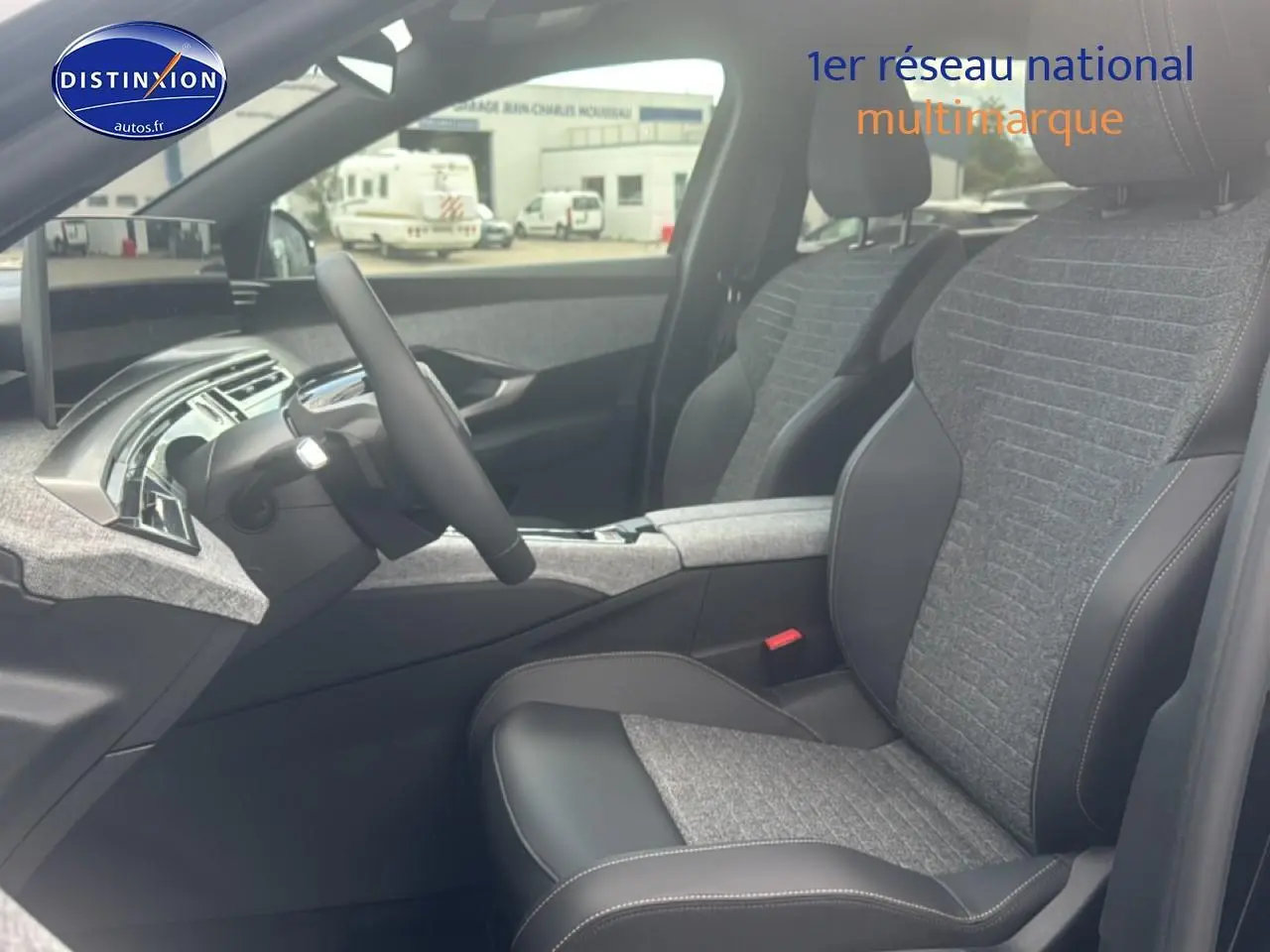 Vue intérieure côté conducteur du Peugeot 5008 Hybrid 145 allure e-dcs6 2025, sièges tissu gris et cuir noir.