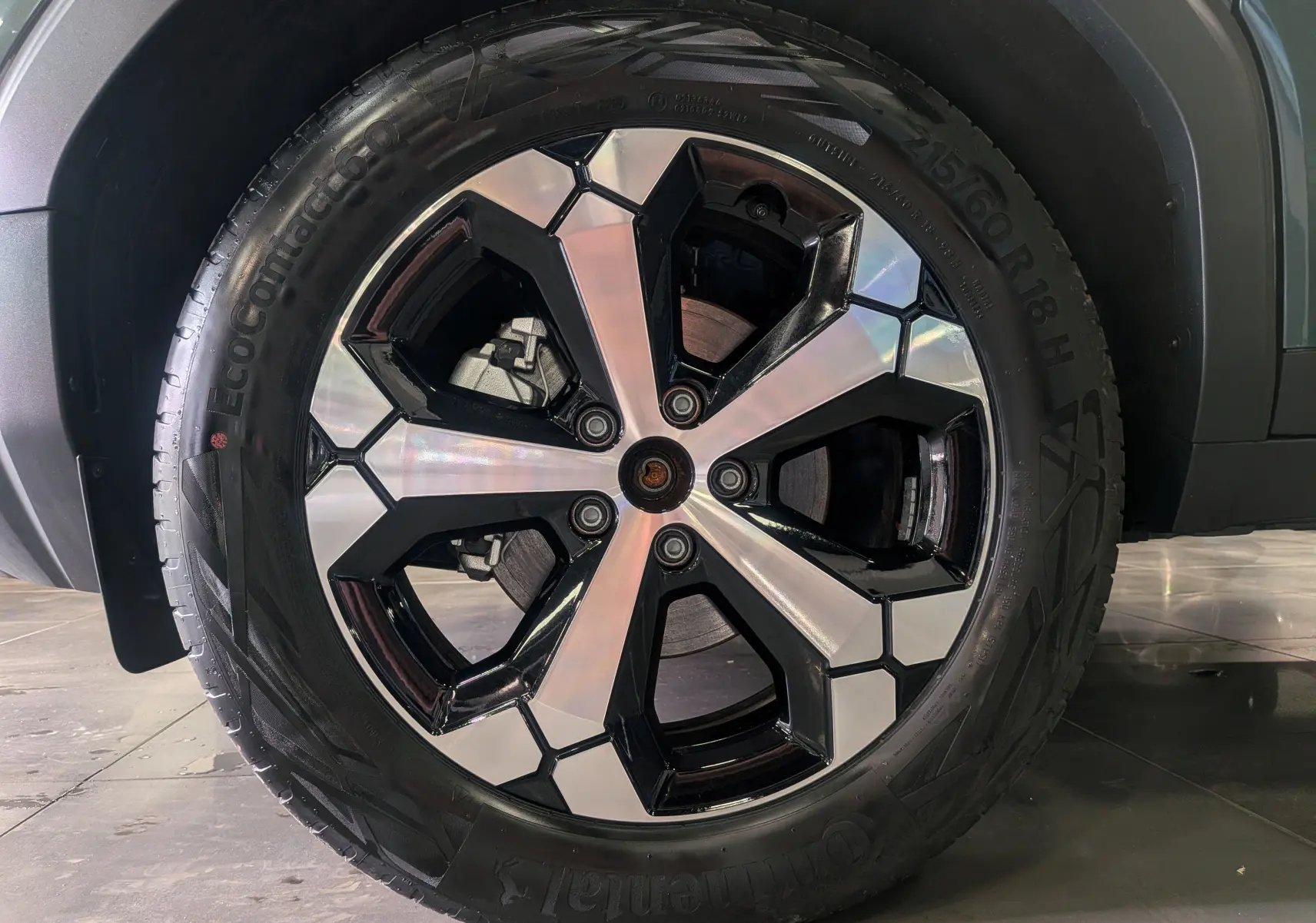 Gros plan sur la roue avant droite du Dacia Bigster Vert Cèdre, jante alliage bicolore au design géométrique.
