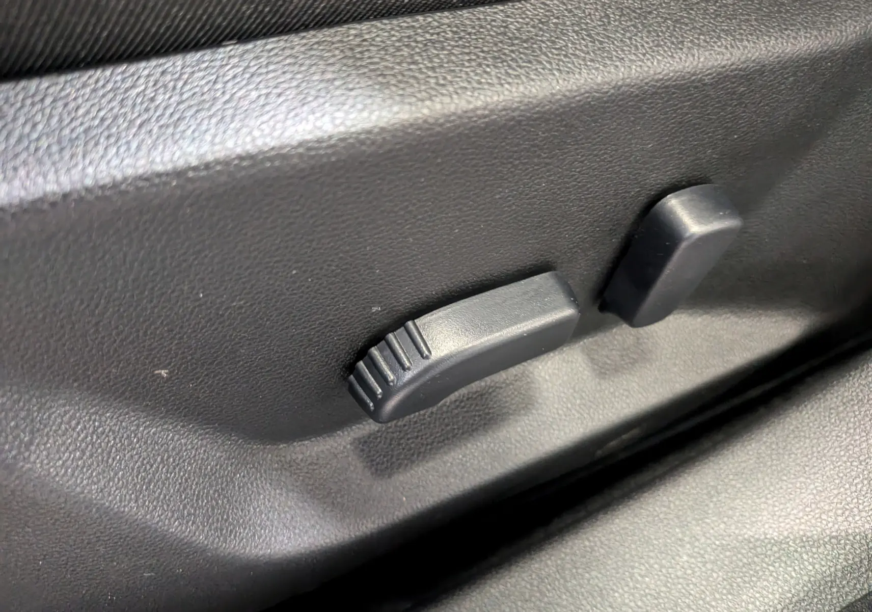 Détail du réglage électrique du siège conducteur noir dans l'habitacle du Dacia Bigster Mild Hybrid 2026.