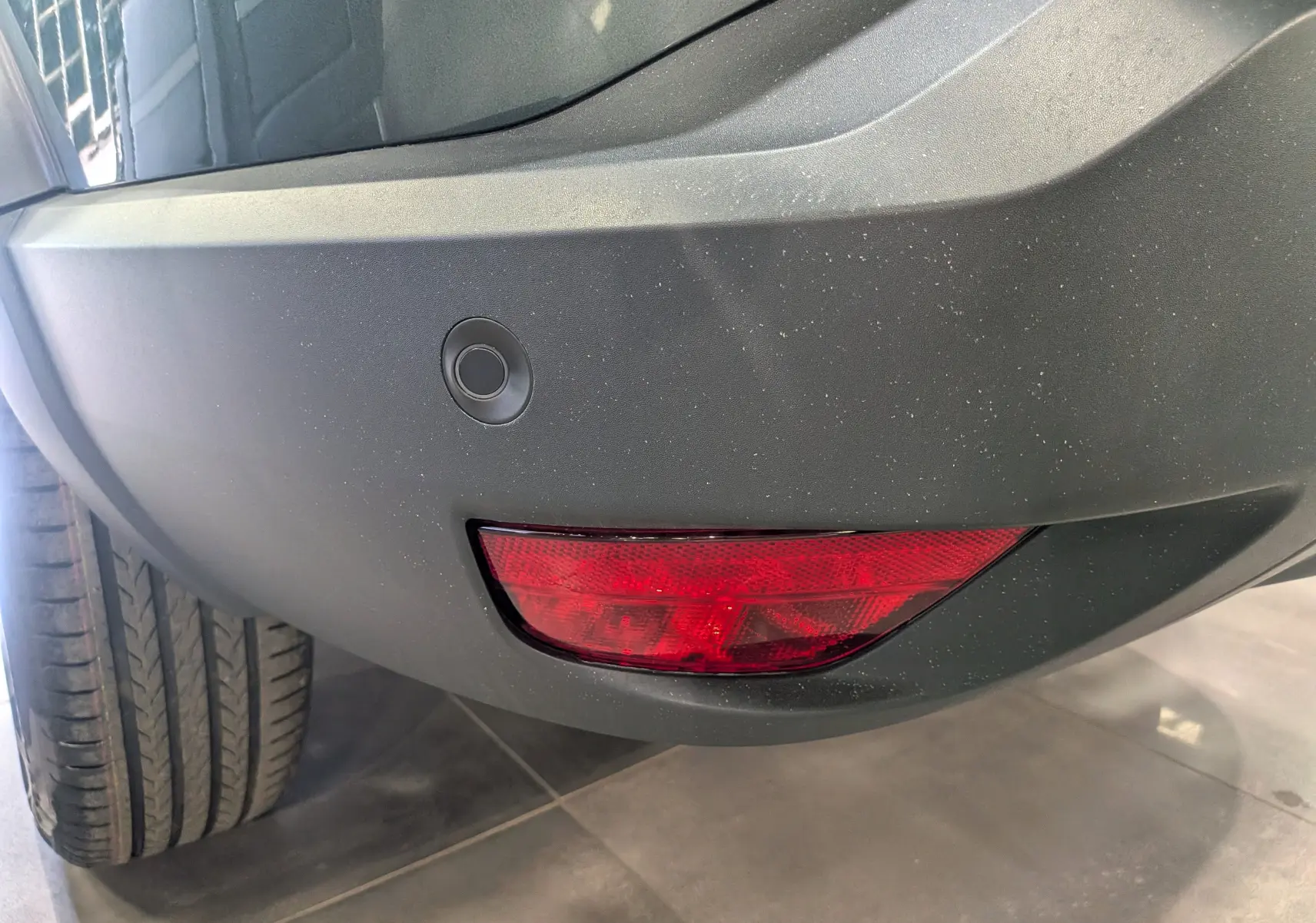 Gros plan sur le feu arrière droit rouge et le pare-chocs vert cèdre du Dacia Bigster Mild Hybrid 2026.