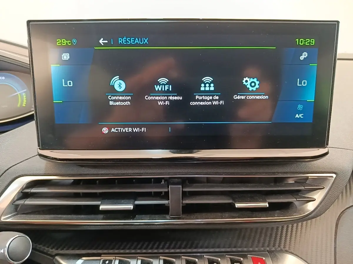 Écran tactile central affichant les options Wi-Fi et Bluetooth du tableau de bord du Peugeot 3008 hybride 2023.