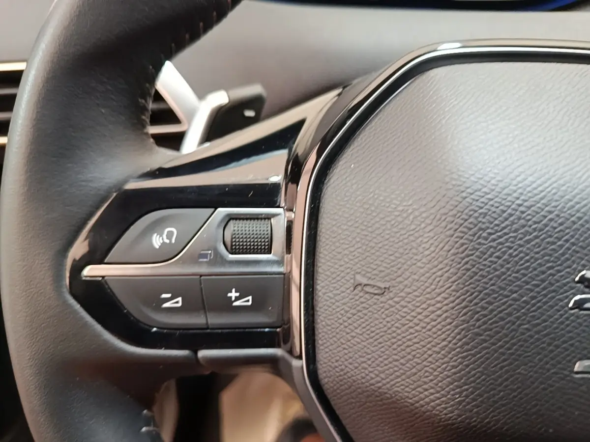 Gros plan sur le volant cuir multifonctions côté gauche du Peugeot 3008 hybride rechargeable 2023.
