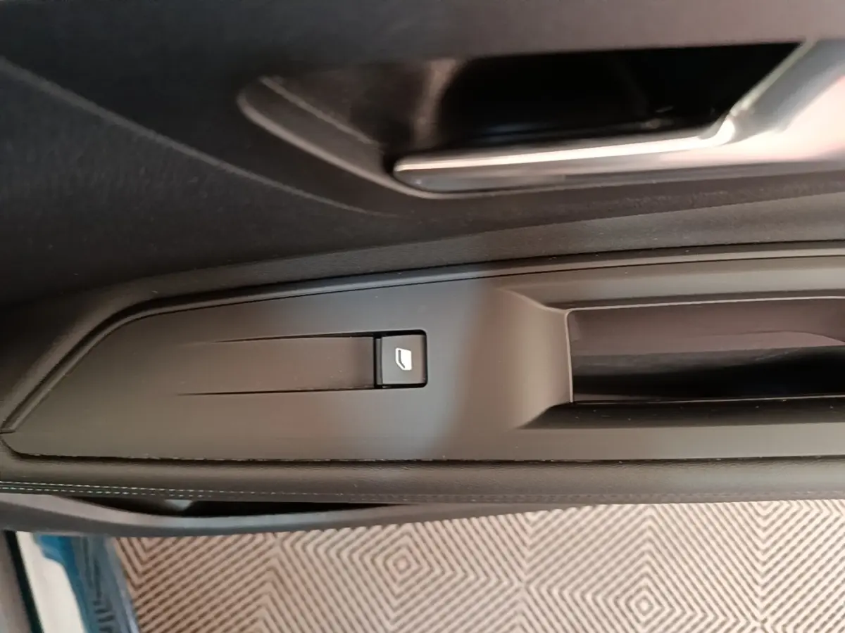 Détail de la commande de lève-vitre sur la porte côté gauche d’un Peugeot 3008 bleu hybride rechargeable 2023.
