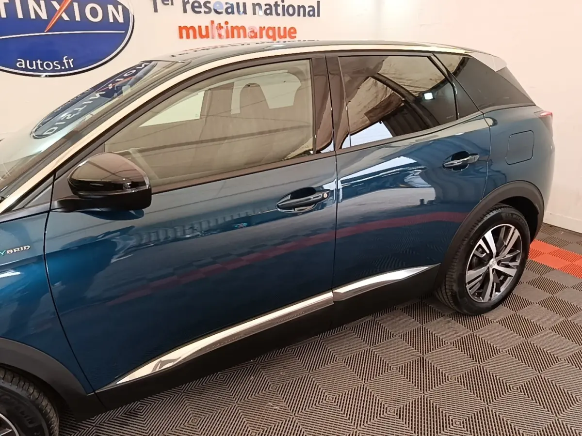 Vue latérale côté gauche d’un Peugeot 3008 hybride rechargeable bleu 2023 avec vitres teintées et jantes alliage.