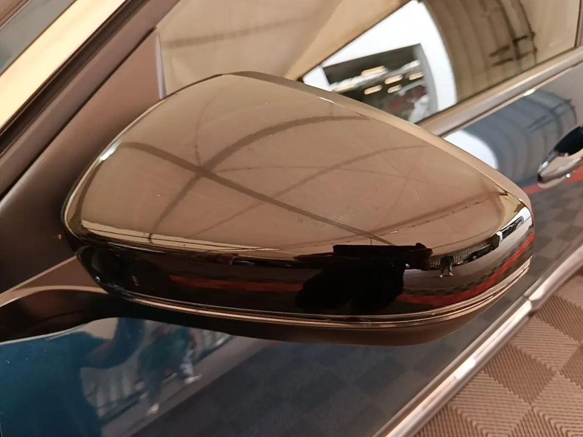 Rétroviseur noir brillant côté gauche du Peugeot 3008 bleu hybride rechargeable, vue rapprochée sur la portière.