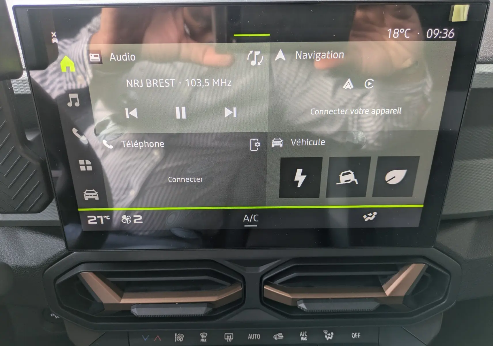 Écran tactile central du tableau de bord du Dacia Duster Hybrid 155 Extreme avec commandes climatisation et finition brun cuivré.