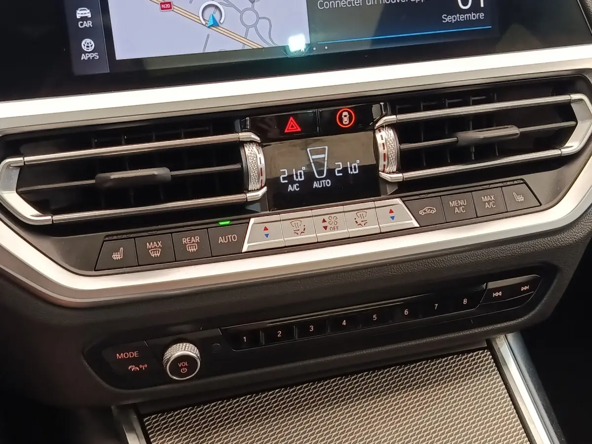 Détail du tableau de bord central de la BMW Série 3 320e M Sport 2022, avec commandes climatisation et écran tactile.