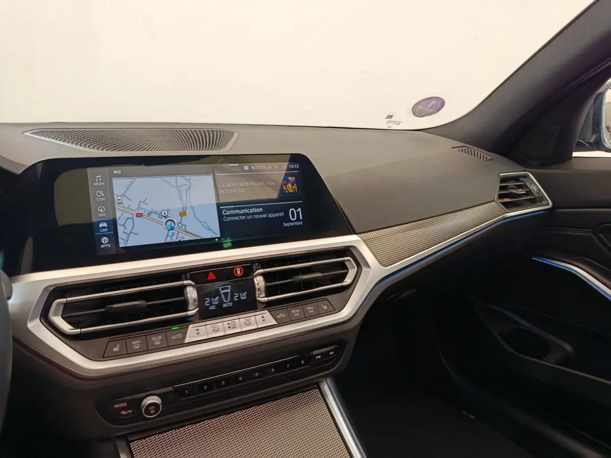 Vue intérieure côté passager de la BMW Série 3 320e M Sport 2022, tableau de bord avec écran tactile et finitions gris foncé.