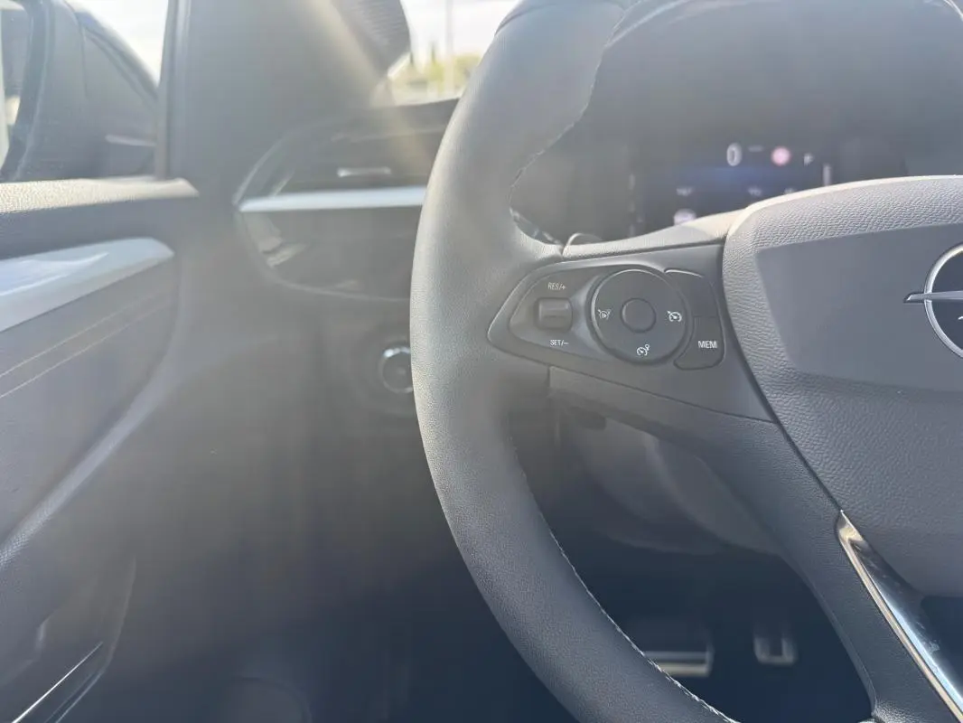 Intérieur noir d’une Opel Corsa 2025, vue rapprochée du volant avec commandes intégrées côté gauche.