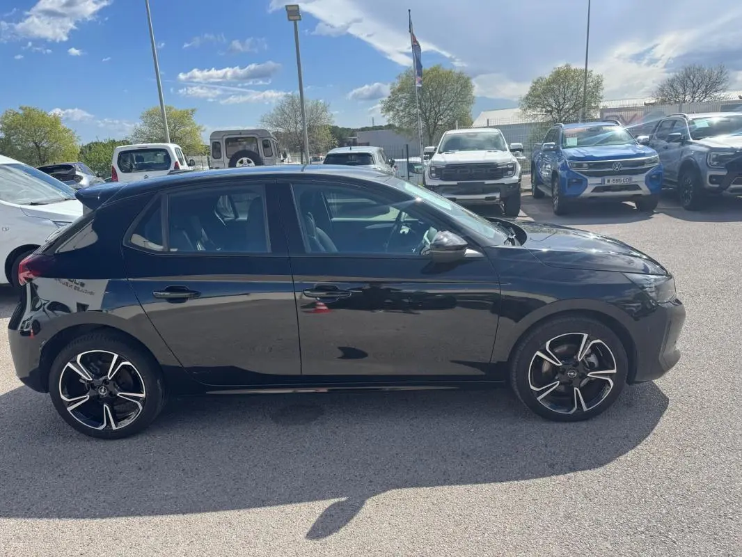 Opel Corsa 2025 noire vue de profil côté gauche, avec jantes alliage noires et détails chromés sur les rétroviseurs.