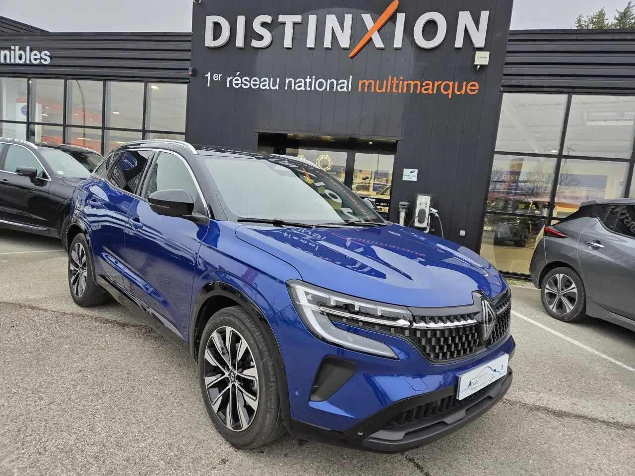 Renault Austral E-Tech hybride bleu Iron vue 3/4 avant avec toit noir et jantes alliage noires.