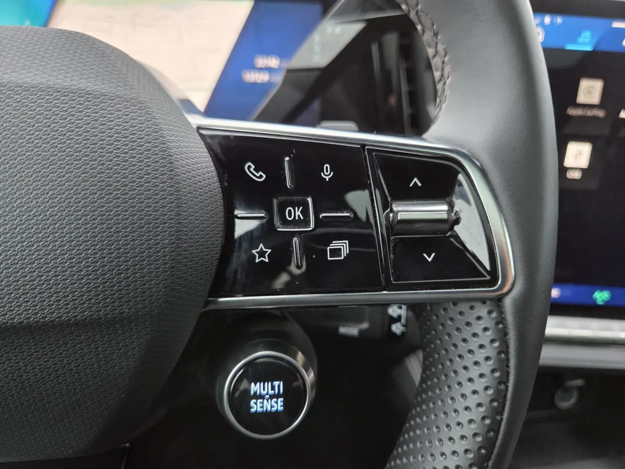 Gros plan sur les commandes gauche du volant du Renault Austral 2025 avec bouton Multi-Sense éclairé.