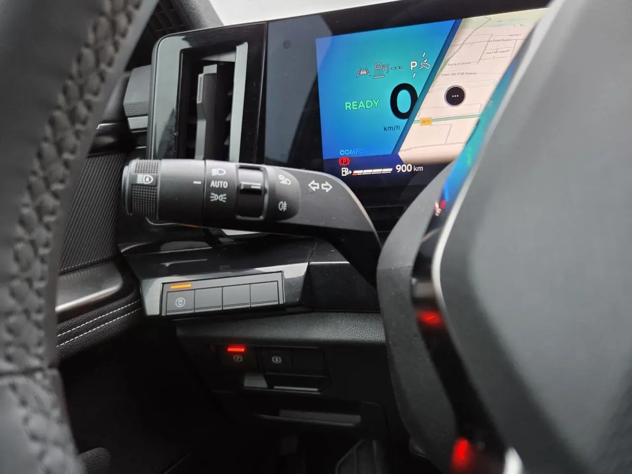 Vue rapprochée du tableau de bord et du commodo gauche du Renault Austral E-Tech, avec écran digital et commandes éclairage.