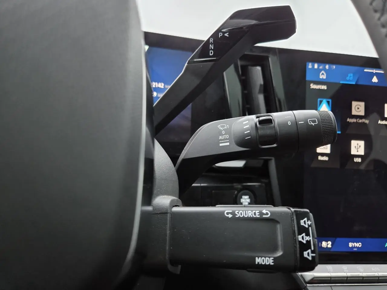 Gros plan sur les commandes au volant du Renault Austral E-Tech 2025, avec écran tactile et levier de vitesses visible.