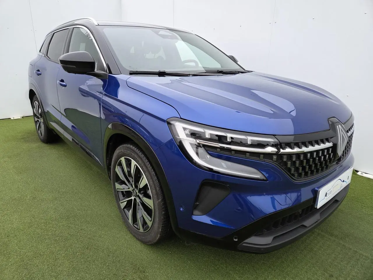 Renault Austral E-Tech hybride bleu Iron vue 3/4 avant gauche avec toit noir et jantes alliage noires.