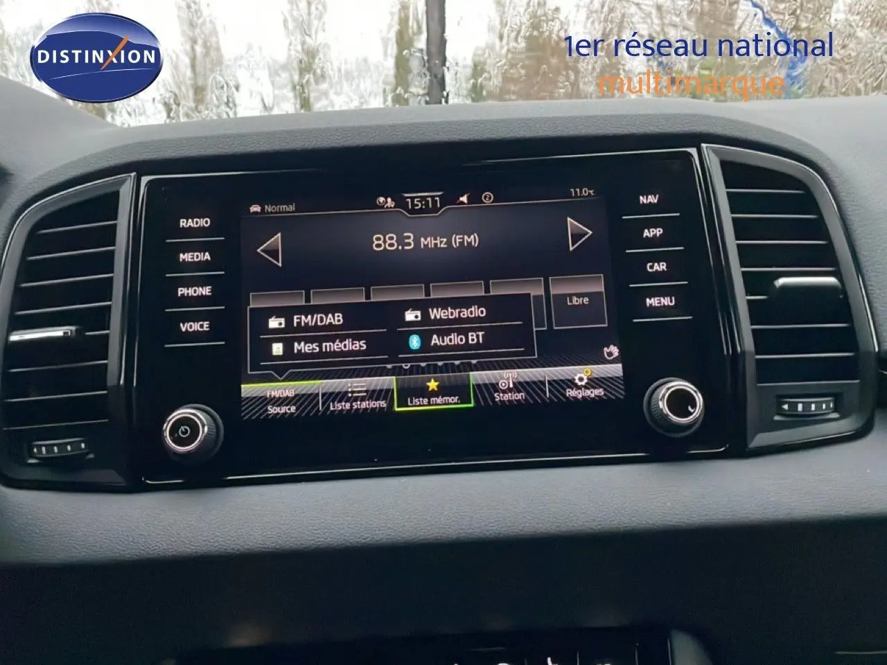 Écran central tactile du Skoda Karoq 2025 affichant les options radio et médias, entouré de commandes noires.