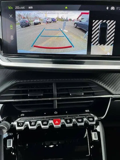 Vue de l'écran central du Peugeot 2008 GT 2024 montrant la caméra de recul avec guidage dynamique et tableau de bord noir.