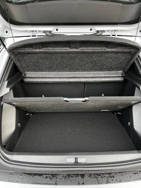 Coffre ouvert vu de dessus d'une Peugeot 2008 blanche 2024, montrant le double plancher de rangement.