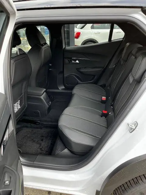 Vue intérieure arrière côté droit du Peugeot 2008 blanc 2024, sièges arrière en tissu noir avec surpiqûres grises.