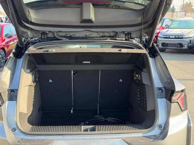 Coffre ouvert vu de l'arrière d'un Renault Scenic E-Tech gris schiste, montrant l'espace de rangement et la trappe à skis.