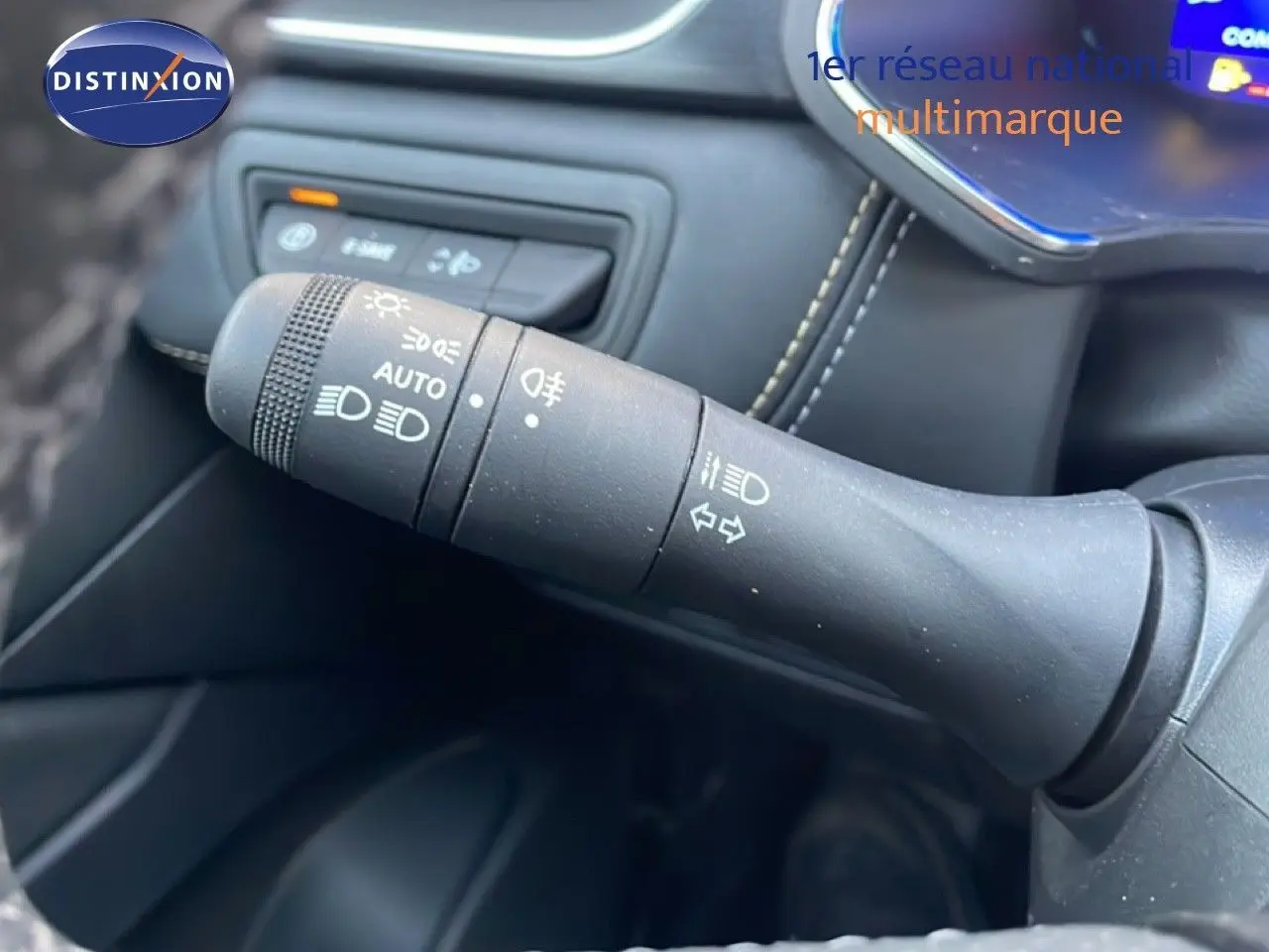 Gros plan sur la commande des feux et clignotants dans l’habitacle noir du Renault Symbioz gris cassiopée.