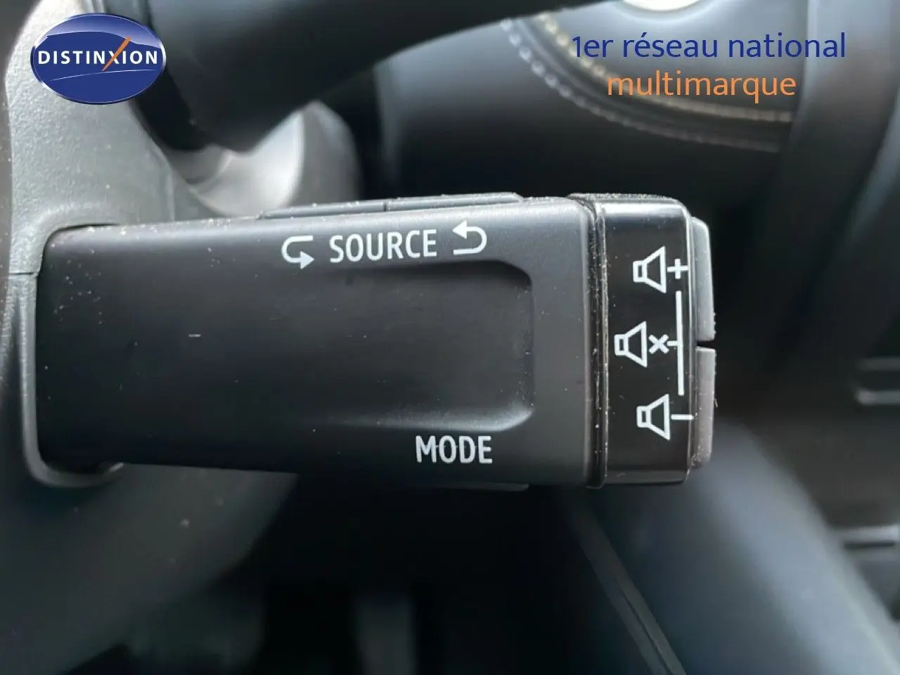 Gros plan sur la commande au volant avec fonctions source et mode du Renault Symbioz gris cassiopée métal.