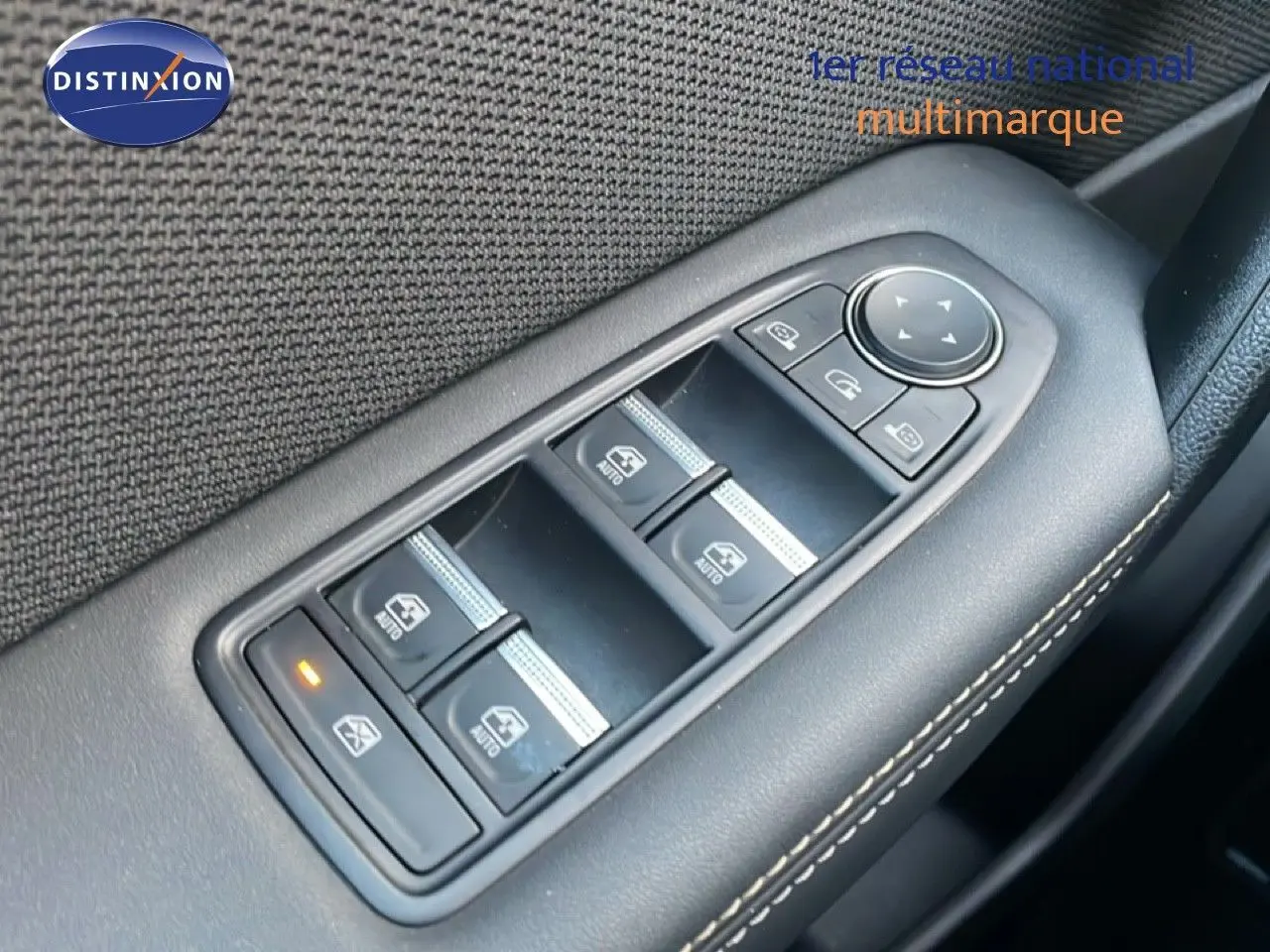 Gros plan sur les commandes de lève-vitres et rétroviseurs côté conducteur d'un Renault Symbioz gris cassiopée métal.