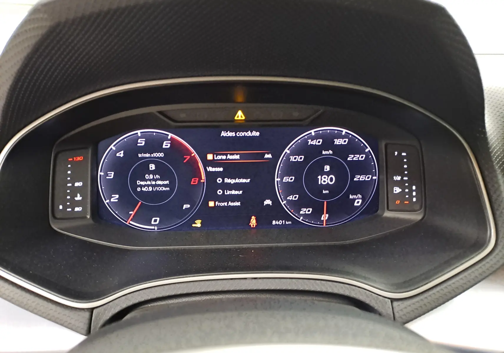 Tableau de bord numérique du SEAT Arona 2024 affichant 180 km/h, aides à la conduite et compte-tours en vue frontale.