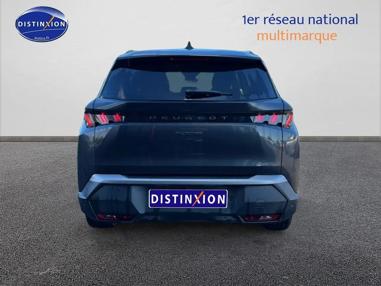 Vue arrière d'un Peugeot 5008 Hybrid 145 allure gris titane avec feux LED et becquet arrière visible.