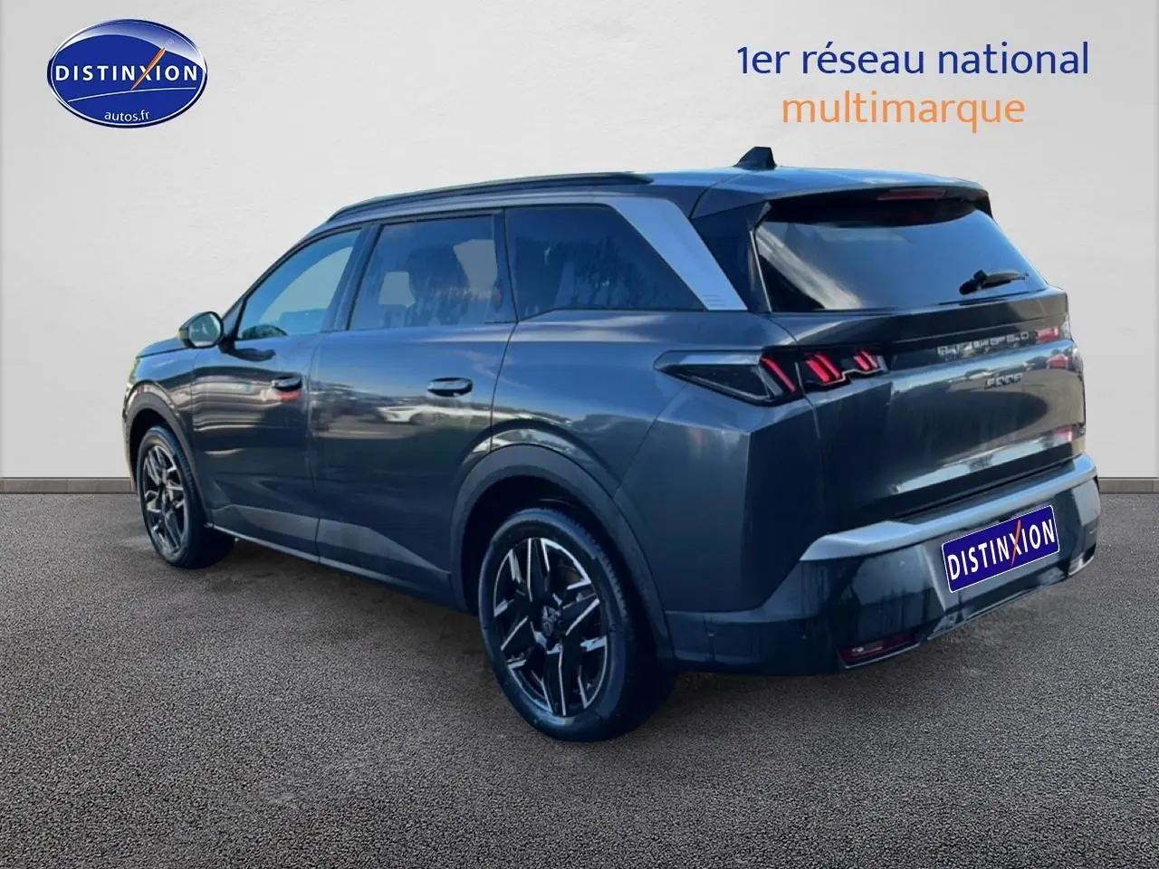 Vue 3/4 arrière droite d’un Peugeot 5008 Hybrid 145 allure gris titane avec jantes alu et feux arrière LED distinctifs.