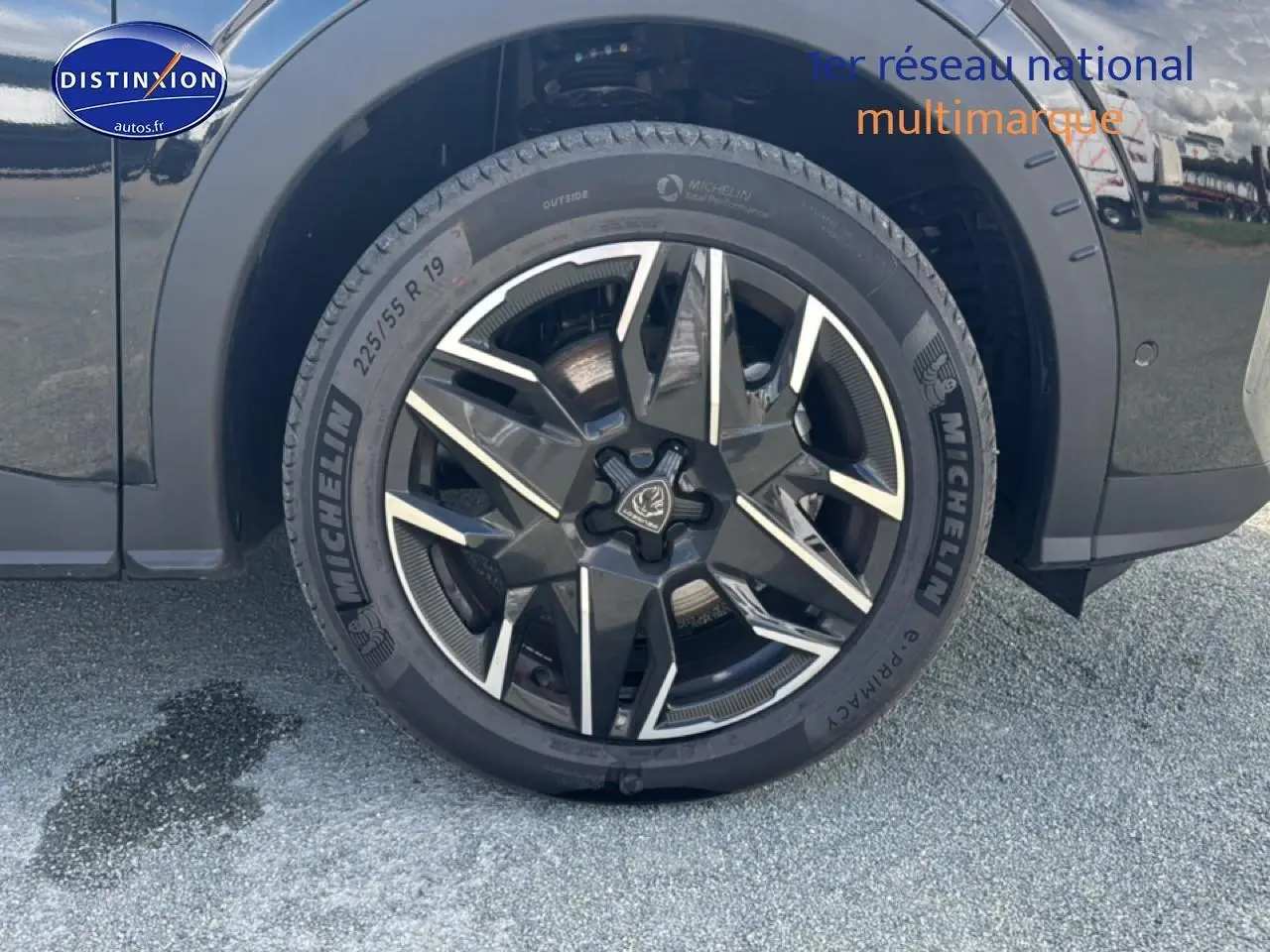 Gros plan sur la roue avant droite noire du Peugeot 5008 Hybrid 145 allure e-dcs6 avec jante alu stylisée.
