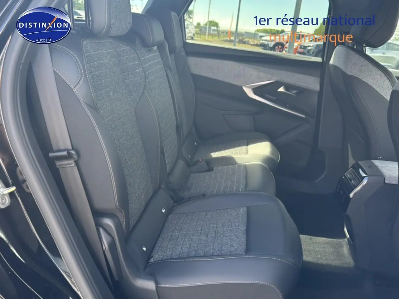 Vue latérale droite de l'intérieur arrière du Peugeot 5008 noir, montrant les sièges en tissu et cuir gris.