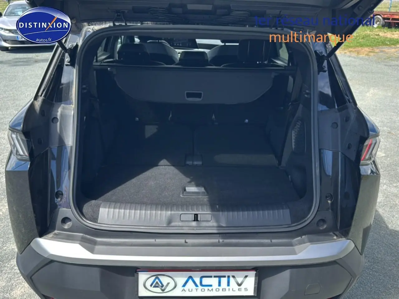 Coffre ouvert en vue arrière d’un Peugeot 5008 Hybrid 145 allure e-dcs6 noir, montrant l’espace de chargement.