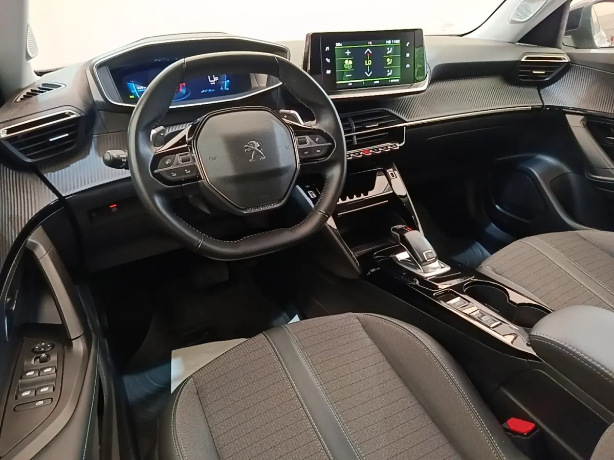 Intérieur Peugeot 2008 PureTech 130 2022 vu côté conducteur, tableau de bord moderne avec écran tactile et volant cuir multifonctions.