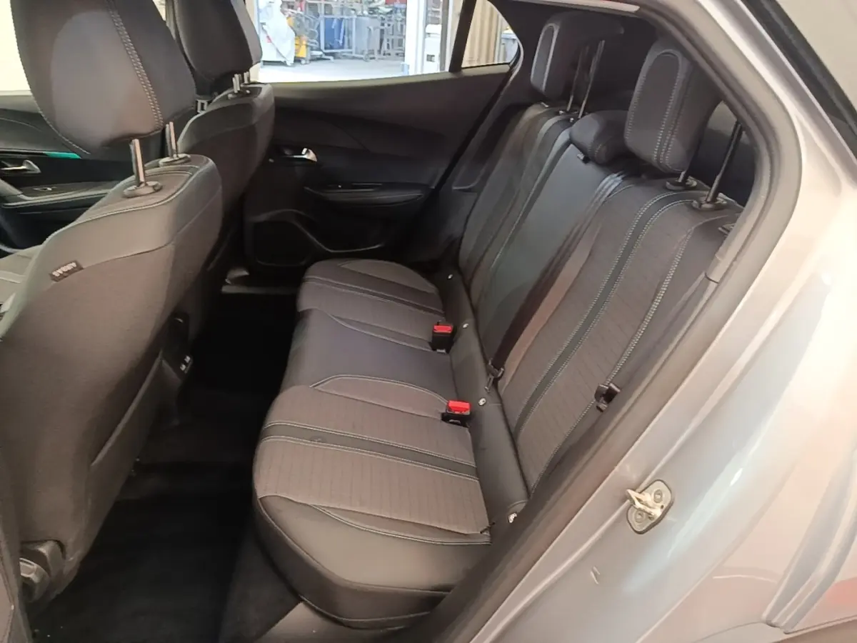 Vue intérieure côté droit des sièges arrière en tissu gris foncé du Peugeot 2008 gris clair, avec ceinture de sécurité rouge visible.