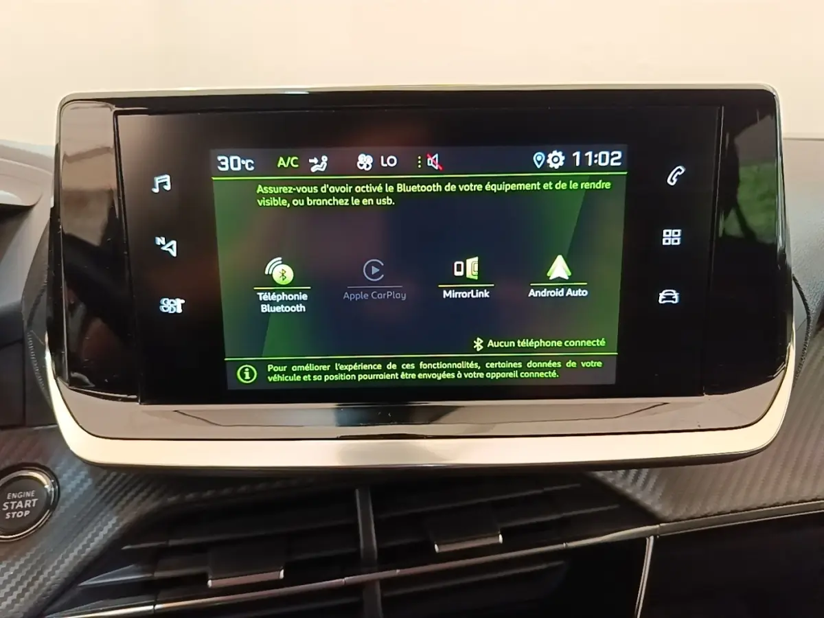 Écran tactile central du tableau de bord du Peugeot 2008 gris clair, affichant les options Bluetooth et Apple CarPlay.