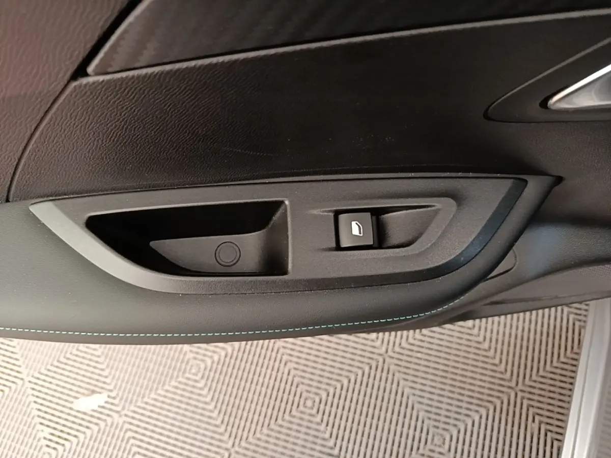 Détail de la poignée intérieure de porte côté gauche du Peugeot 2008 gris clair avec bouton de verrouillage.