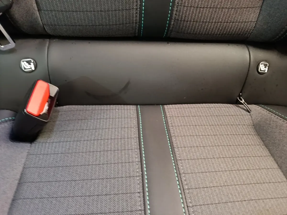 Gros plan sur la banquette arrière gris foncé avec coutures vertes et ceinture de sécurité rouge de la Peugeot 2008 2022.