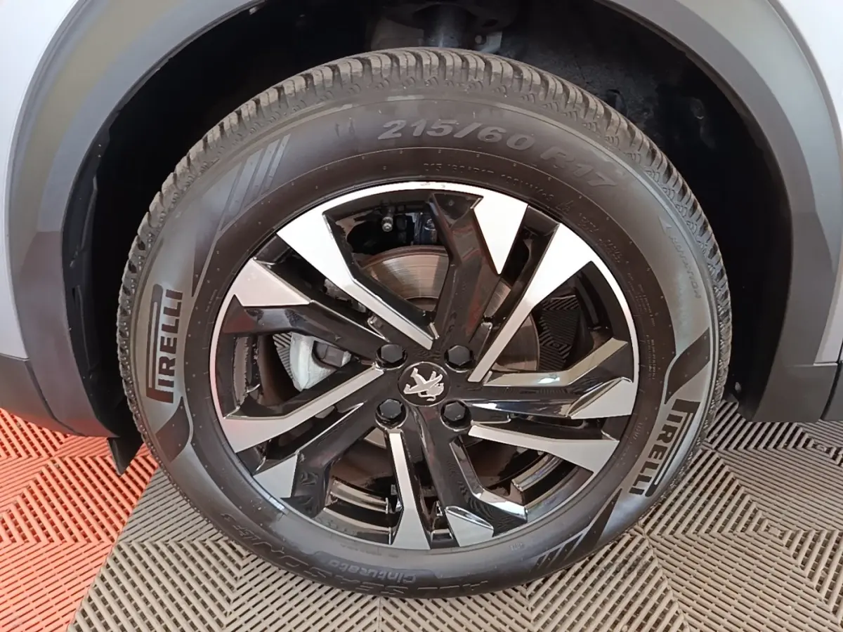 Gros plan sur la roue avant droite de la Peugeot 2008 gris clair, jante alliage noire et argent avec pneu Pirelli.